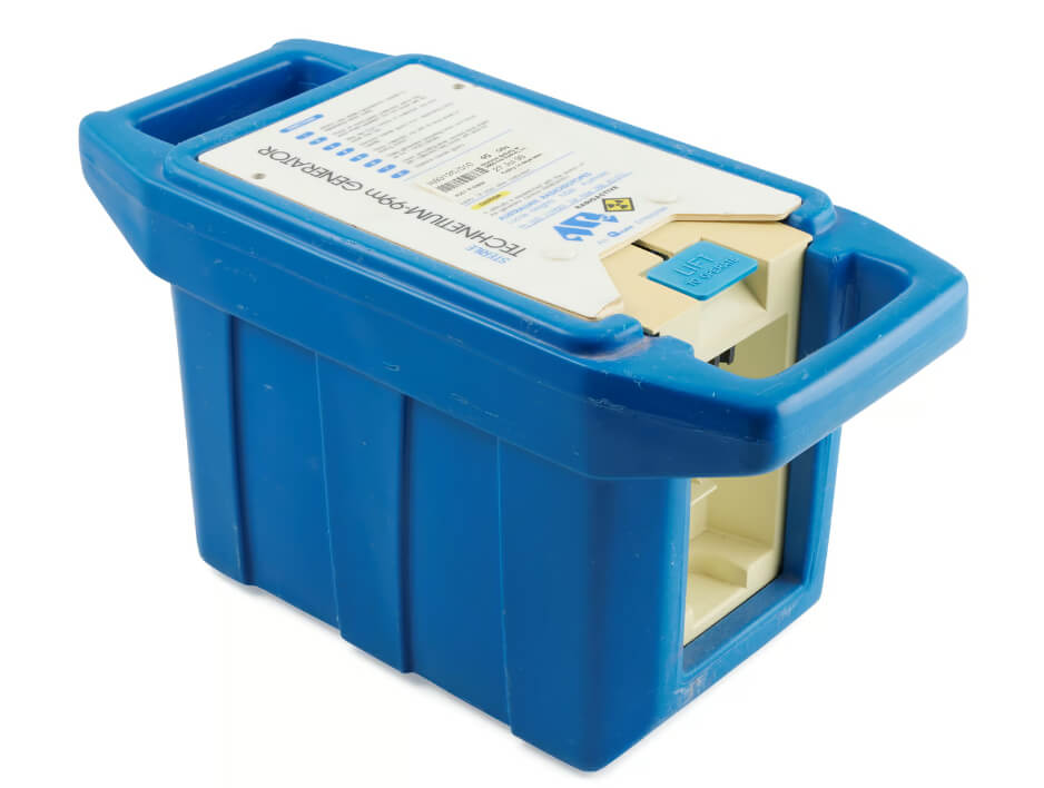 The first version of the ANSTO generator. A blue rectangular box with two handles on either side, a white top information written on it.